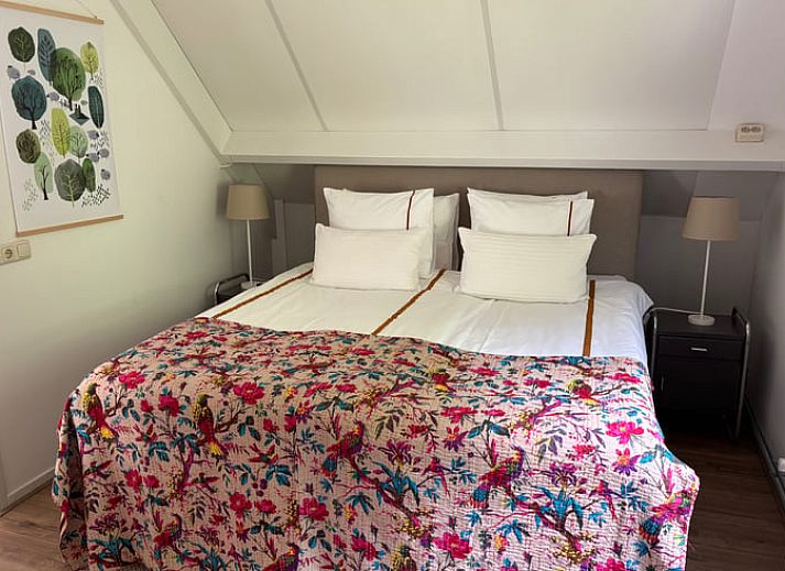 Gezellige slaapkamer in vakantiehuis Huisje in Klarenbeek, Veluwe met tweepersoonsbed en warme sfeer.