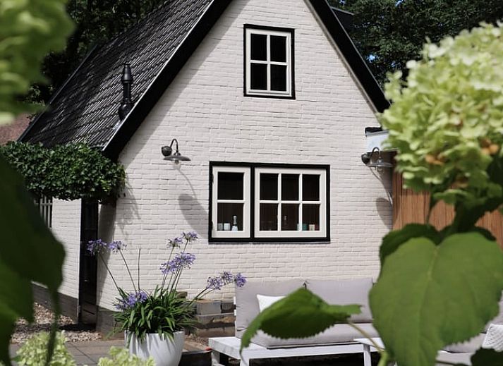 Vacation home in Ugchelen in the Veluwe, Gelderland with cozy porch and green surroundings.