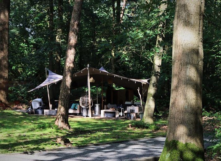 Vacation home in Ugchelen in the Veluwe, Gelderland with cozy porch and green surroundings.