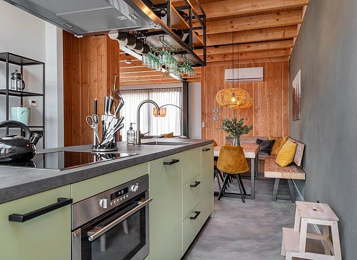 Huisje in Veessen, een rustiek vakantiehuis op de Veluwe in Gelderland, met houten gevel en bloementuin.