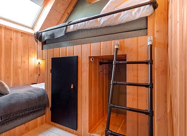 Gezellige eetruimte in Huisje in Veessen, vakantiehuis op de Veluwe, met houten meubels en sfeervolle verlichting.