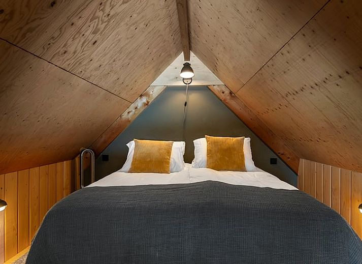 Gezellige eetruimte in Huisje in Veessen, vakantiehuis op de Veluwe, met houten meubels en sfeervolle verlichting.