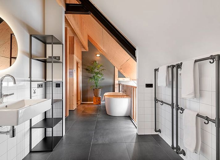 Gemuetliches Wohnzimmer des Ferienhauses in Veessen, Veluwe, Gelderland, mit Holzofen und bequemer Sitzecke.