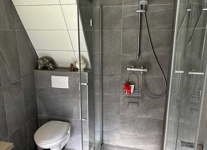 Sonnige Terrasse mit Sonnenschirm am Ferienhaus Cottage in Houtdorp, Ermelo, Veluwe, Gelderland.