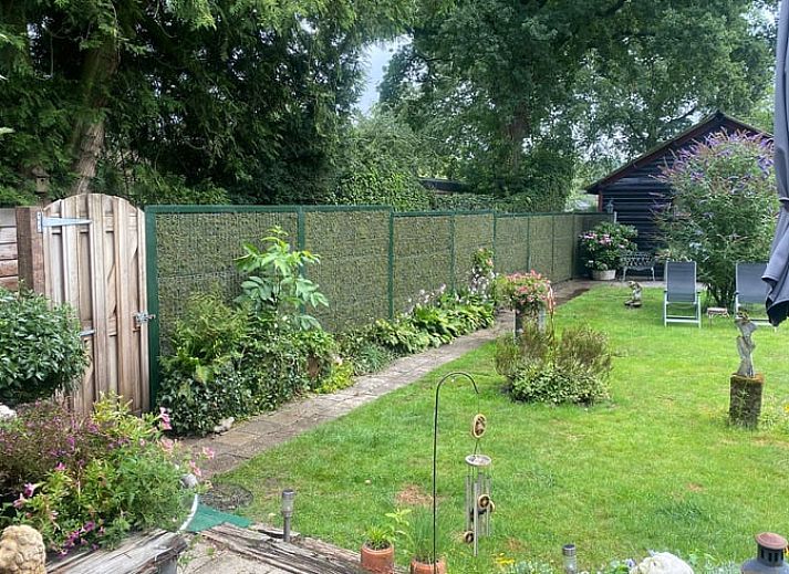 Sonnige Terrasse mit Sonnenschirm am Ferienhaus Cottage in Houtdorp, Ermelo, Veluwe, Gelderland.