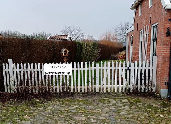 Gezellige woonkamer in Vakantiehuisje in Uithuizermeeden, Noordoost Groningen, met comfortabele bank en planten.