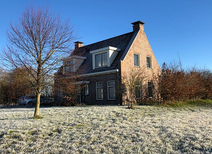 Cottage in Kloosterburen, Ferienhaus in Groningen mit weitem Feld und blauem Himmel.