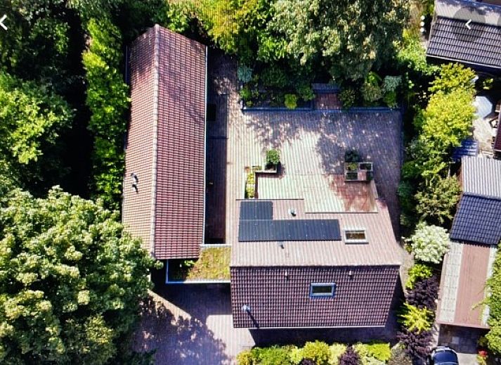 Robbenoort 127, 'Lauwie' vakantiehuis in Lauwersoog, Groningen, omgeven door groene natuur en rustieke architectuur.