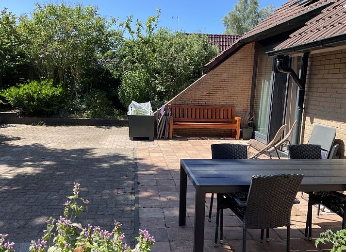 Robbenoort 127, 'Lauwie' vakantiehuis in Lauwersoog, Groningen, omgeven door groene natuur en rustieke architectuur.