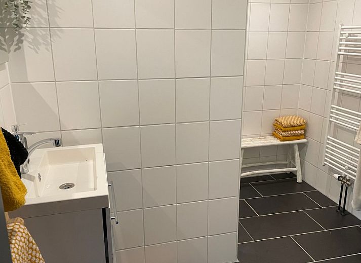 Zonnig terras bij Robbenoort 127, 'Lauwie' vakantiehuis in Lauwersoog, Groningen, ideaal voor ontspanning in de natuur.