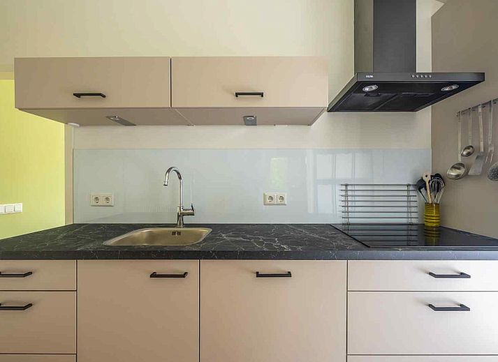 Gezellige woonkamer van GR032 vakantiehuis in Lauwersoog, Groningen met uitzicht op de tuin.