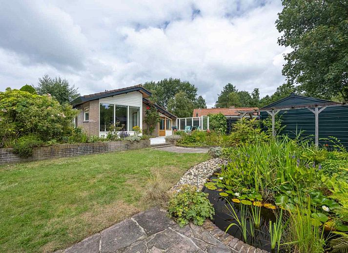 Gezellige woonkamer van GR032 vakantiehuis in Lauwersoog, Groningen met uitzicht op de tuin.