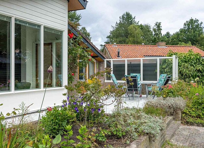 Gezellige woonkamer van GR032 vakantiehuis in Lauwersoog, Groningen met uitzicht op de tuin.