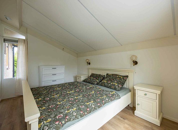 Zonnig terras bij GR032 vakantiehuis in Lauwersoog, omgeven door bloeiende planten.