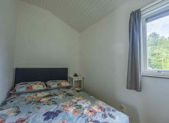 Zonnig terras bij GR032 vakantiehuis in Lauwersoog, omgeven door bloeiende planten.