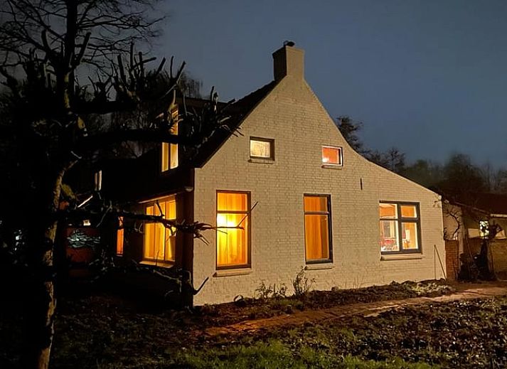 Vakantiehuisje in Vierhuizen, charmant wit huisje in Noordwest Groningen met rode dakpannen en groene omgeving.