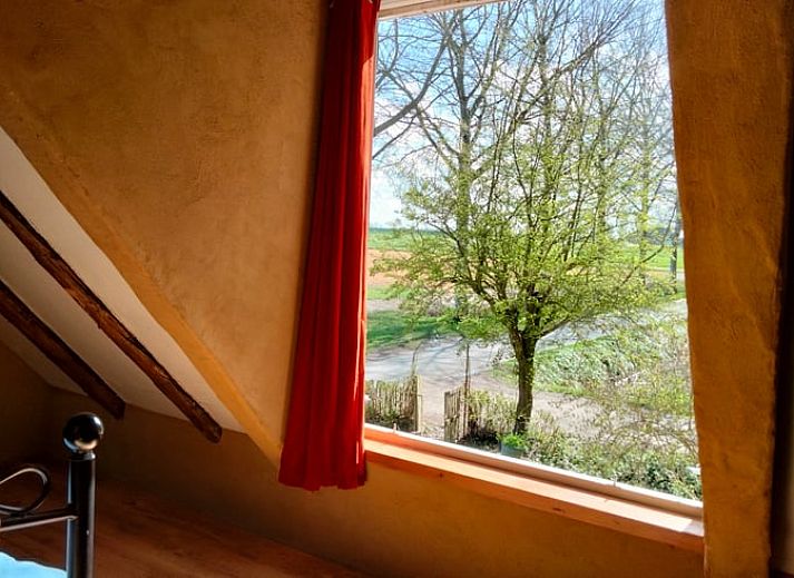 Vakantiehuisje in Vierhuizen, charmant wit huisje in Noordwest Groningen met rode dakpannen en groene omgeving.