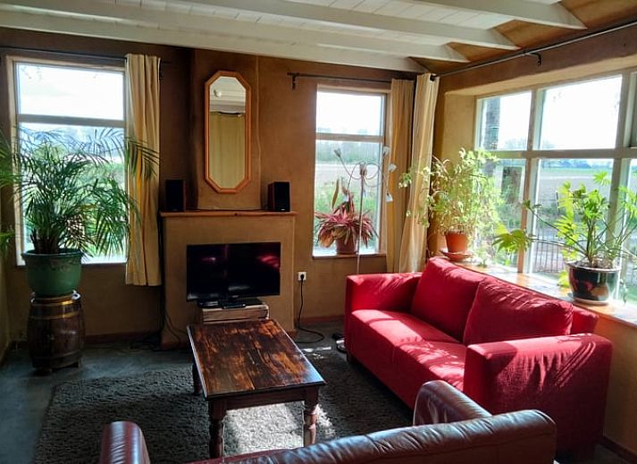 Uitzicht vanuit de slaapkamer van Vakantiehuisje in Vierhuizen, met groene bomen en landelijke weg.