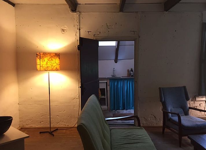 Groene tuin met zitbank bij Vakantiehuisje in Vriescheloo, Zuidoost Groningen, biedt een vredige plek om te ontspannen te midden van de natuur.