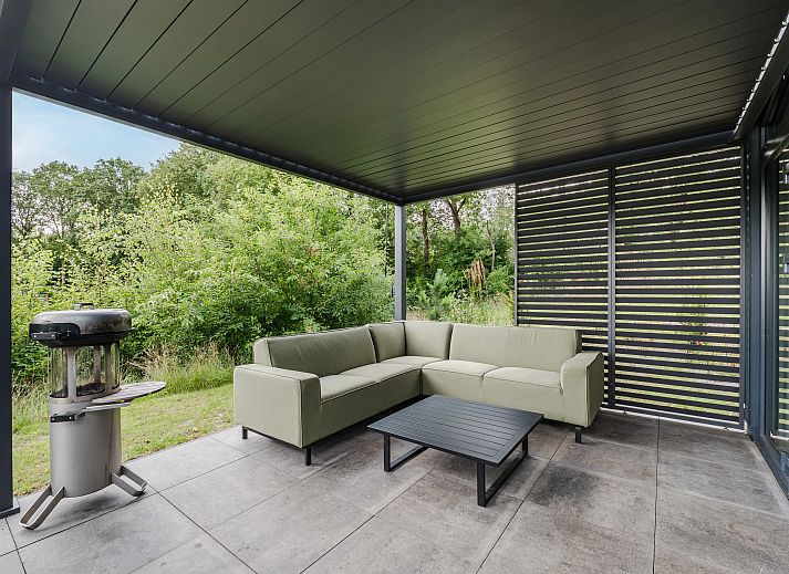 Stijlvolle woonkamer in 4-persoons woning 4L2, Sellingen, met comfortabele bank.