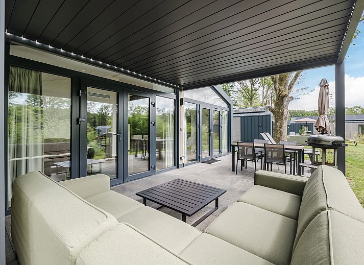 Stijlvolle woonkamer in 4-persoons woning 4L2, Sellingen, met comfortabele bank.