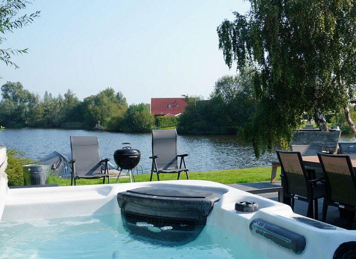 Speeltoestellen en uitzicht op de tuin bij Vakantiehuis Lethehuis in Vlagtwedde, Groningen.