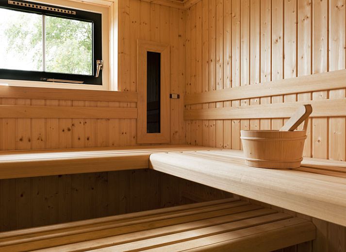 Speeltoestellen en uitzicht op de tuin bij Vakantiehuis Lethehuis in Vlagtwedde, Groningen.