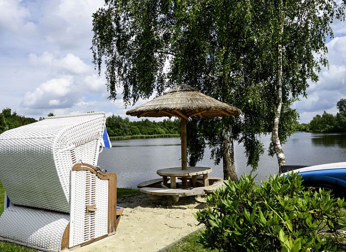 Speeltoestellen en uitzicht op de tuin bij Vakantiehuis Lethehuis in Vlagtwedde, Groningen.