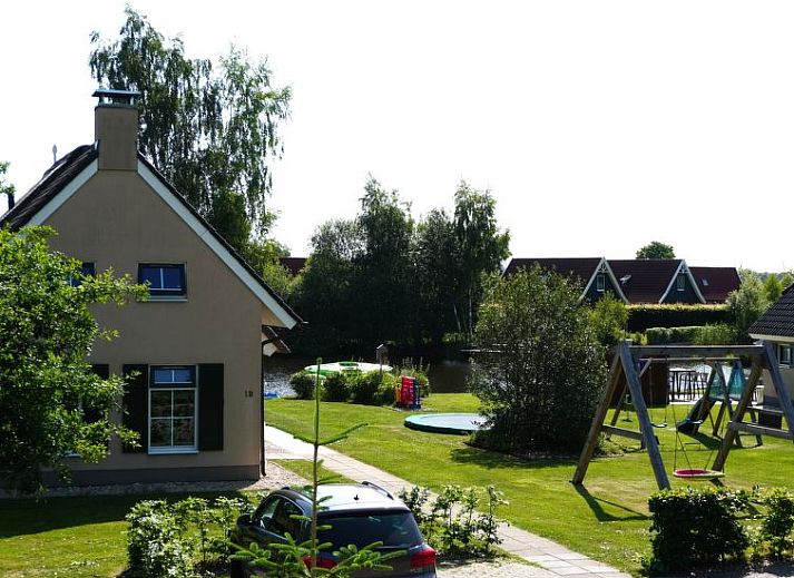 Speeltoestellen en uitzicht op de tuin bij Vakantiehuis Lethehuis in Vlagtwedde, Groningen.