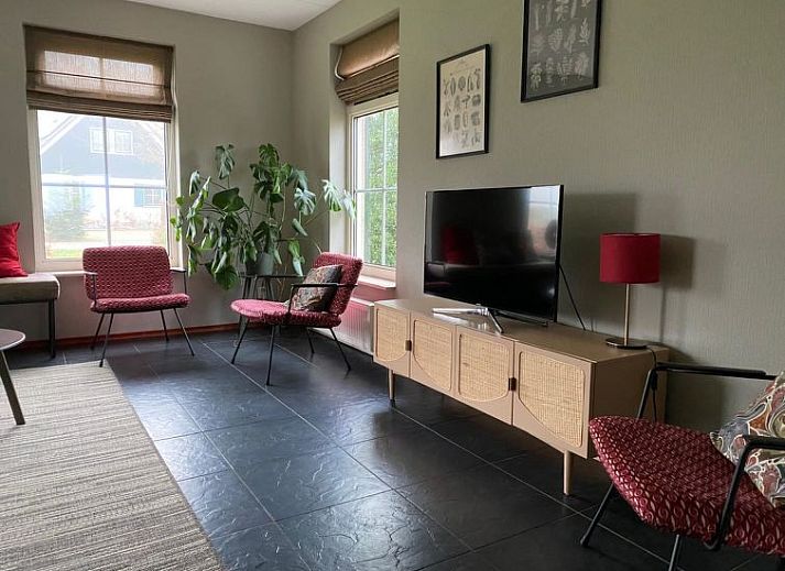 Gezellige woonkamer met bloemendecoratie in Vakantiehuis Lethehuis te Vlagtwedde, Groningen.