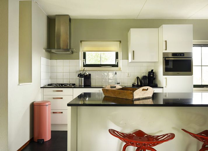 Gezellige woonkamer met bloemendecoratie in Vakantiehuis Lethehuis te Vlagtwedde, Groningen.