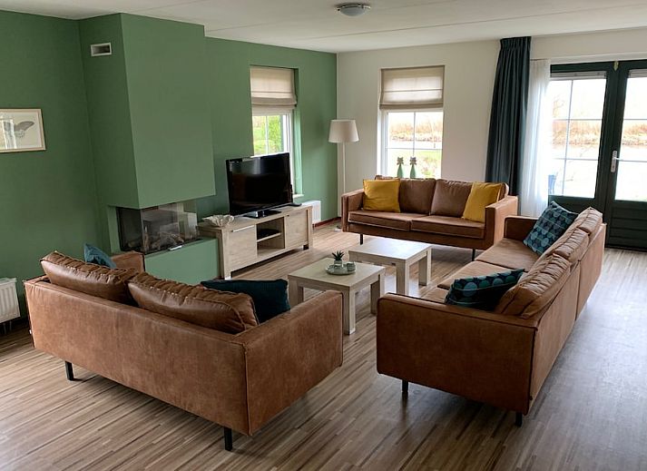 Gemuetliches Wohnzimmer des Bungalows Wellness 14 in Vlagtwedde, suedoestlich von Groningen, mit komfortabler Sitzecke und modernen Moebeln.