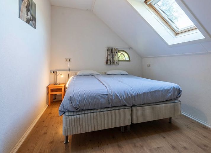 Eethoek in Vakantiehuisje in Wedde, Zuidoost Groningen, met houten tafel en trap naar bovenverdieping.