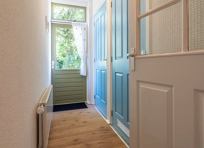 Eethoek in Vakantiehuisje in Wedde, Zuidoost Groningen, met houten tafel en trap naar bovenverdieping.