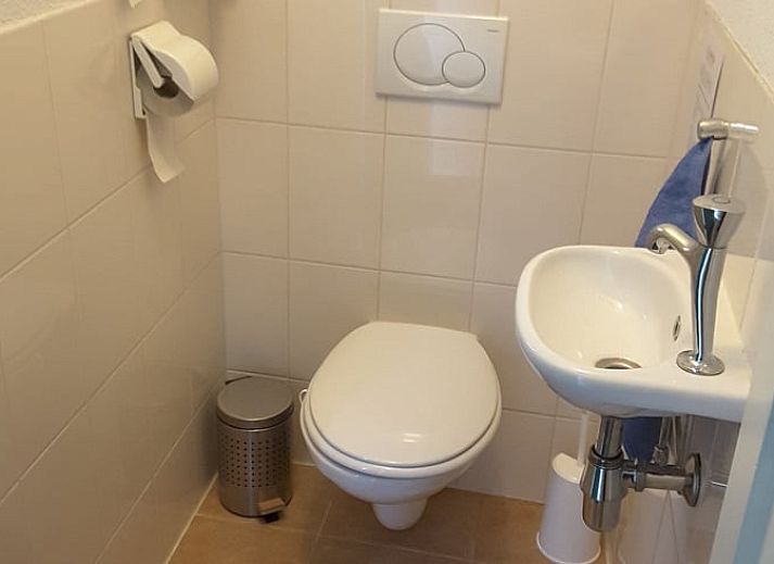 Eethoek in Vakantiehuisje in Wedde, Zuidoost Groningen, met houten tafel en trap naar bovenverdieping.