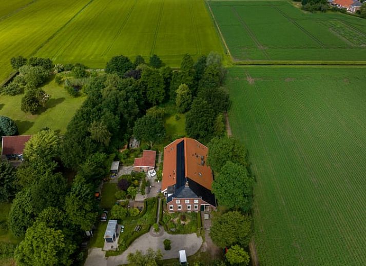 Eethoek in Vakantiehuisje in Wedde, Zuidoost Groningen, met houten tafel en trap naar bovenverdieping.