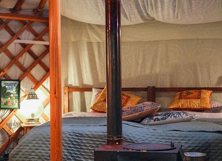 Gezellige woonkamer in Vakantiehuis in Wedde, met comfortabele bank en open haard, perfect voor ontspanning in Groningen.