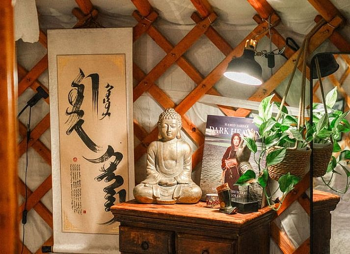 Gezellige woonkamer in Vakantiehuis in Wedde, met comfortabele bank en open haard, perfect voor ontspanning in Groningen.