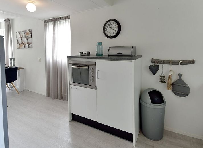 Gezellige woonkamer van Kajuit 4, een bungalow in Steendam, Zuidoost Groningen, met comfortabele stoelen en een moderne inrichting.