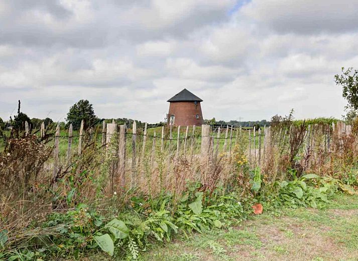 Gezellige woonkamer van GR029 in Tripscompagnie, Groningen met een sfeervolle spiraaltrap en houten balkenplafond.