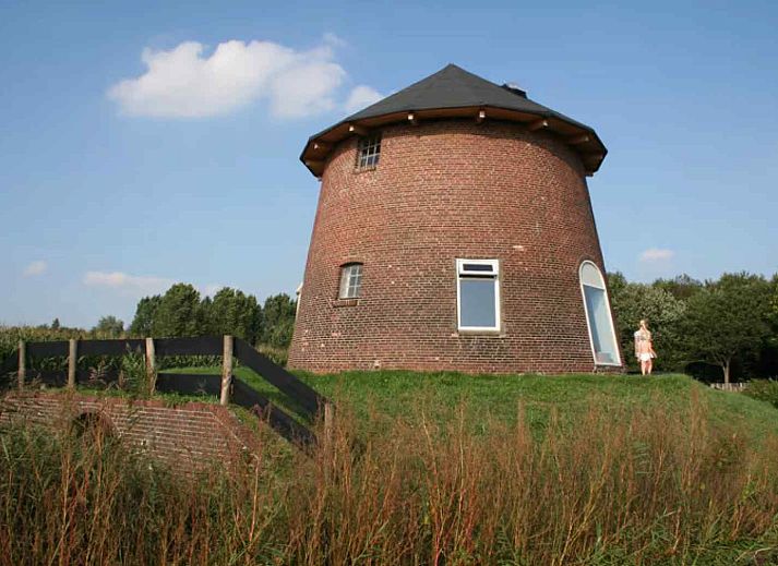 Gezellige woonkamer van GR029 in Tripscompagnie, Groningen met een sfeervolle spiraaltrap en houten balkenplafond.
