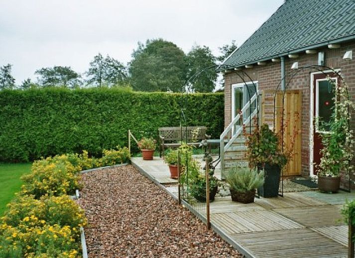 Geniessen Sie die Terrasse der Wohnung De Grienthe in Jonkersvaart, im Suedwesten von Groningen, mit Blick auf den gruenen Garten.