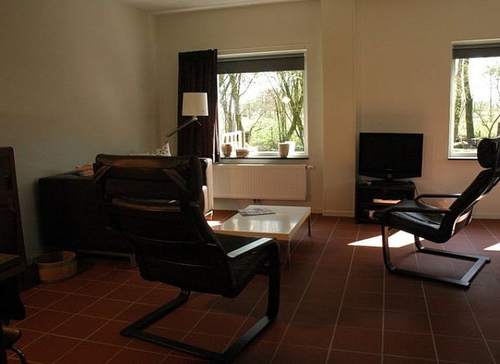 Huisje in Zevenhuizen, groene tuin met bloemen rondom vakantiehuis in Zuidwest Groningen, Groningen.