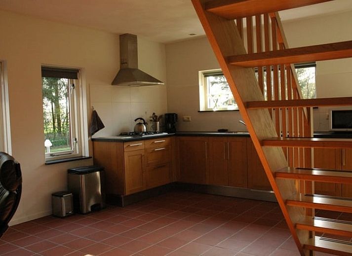 Huisje in Zevenhuizen, groene tuin met bloemen rondom vakantiehuis in Zuidwest Groningen, Groningen.