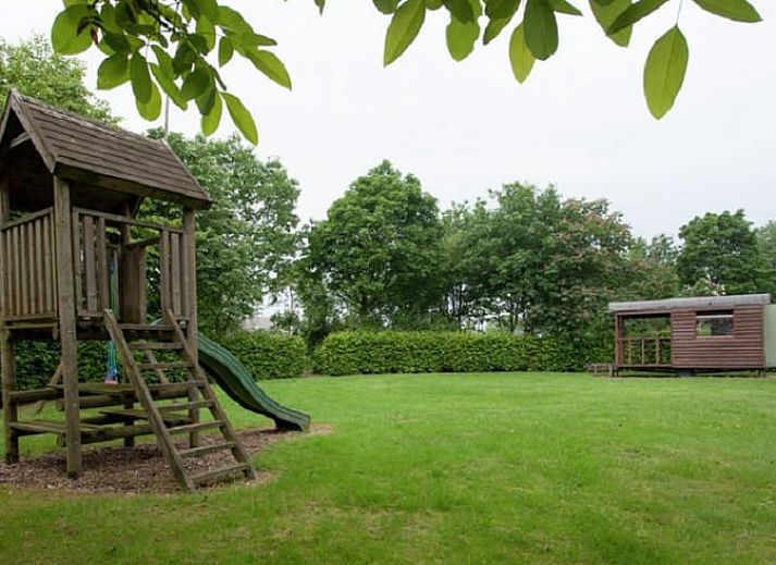 Gezellige woonkamer in Huisje in Leudal, vakantiehuis in Midden Limburg. Warme inrichting met houtkachel en comfortabele zitruimte.