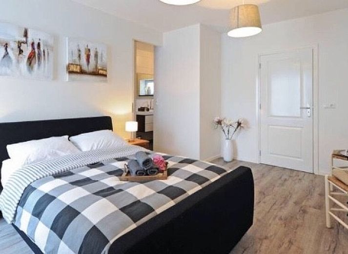 Ruime slaapkamer met houten accenten bij Op Geneijgen, bed and breakfast in Grathem, Midden Limburg.