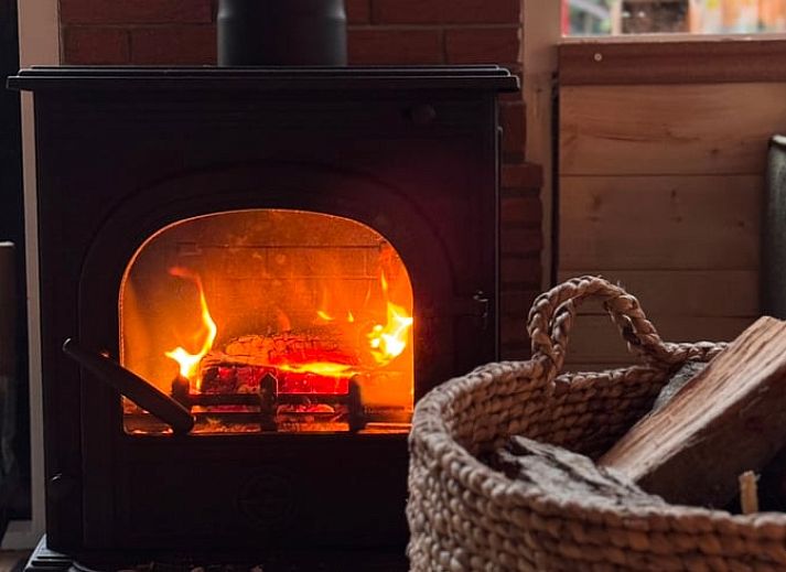 Draufsicht auf das A-Rahmen-Dach des Ferienhauses in Meijel, Mittellimburg, umgeben von hohen Baeumen.