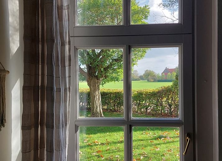 Charmante voordeur van Vakantiehuisje in Well (L), Noord Limburg, met klassieke leeuwenkop op een zonnige dag.