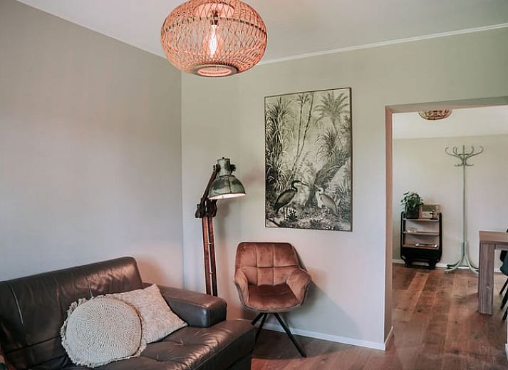 Gezellig terras bij Vakantiehuis in Well, Noord Limburg met eettafel en bloemen.