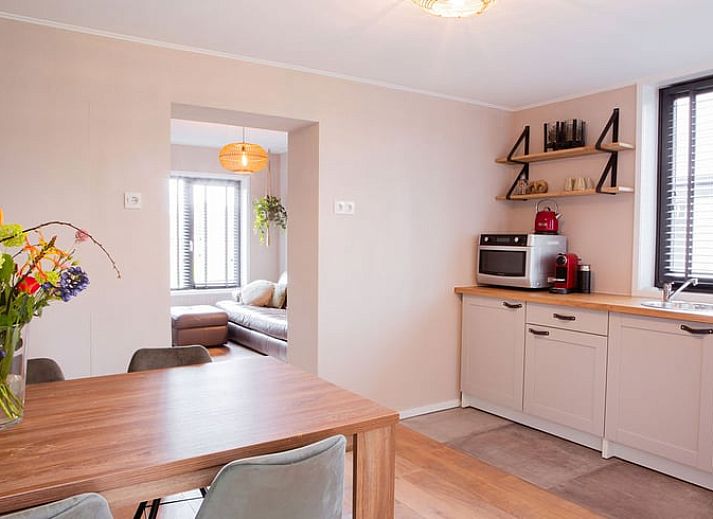 Gezellig terras bij Vakantiehuis in Well, Noord Limburg met eettafel en bloemen.